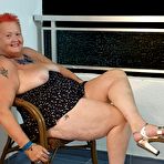 Second pic of Fat nan with short red hair presses her big boobs and butt up against glass