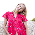 Second pic of Young natural blonde Beti gets bare naked against a round hay bale in a field